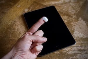 Toothpaste on a finger with a scratched iPad.