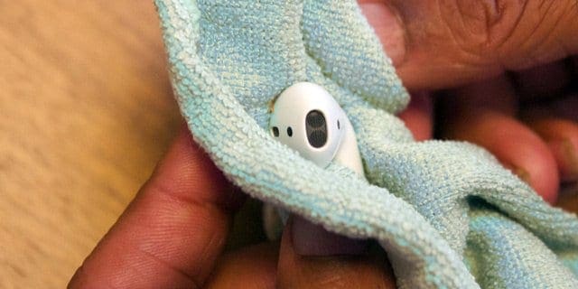 AirPod being cleaned in a microfiber cloth