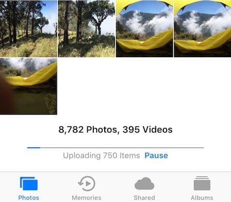 Screenshot of the Photos app in the process of uploading 750 items
