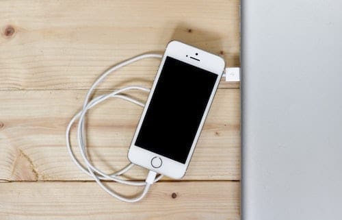 Photo of an iPhone with a cable connecting it to a computer
