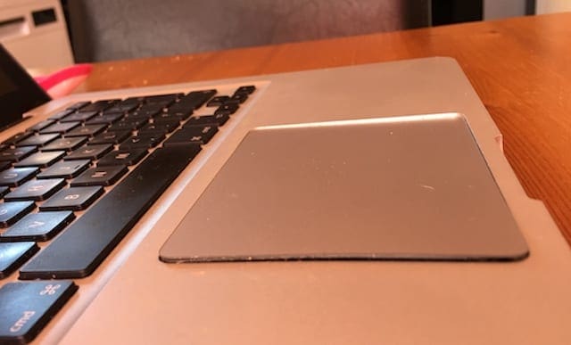 MacBook with raised or lifted trackpad.