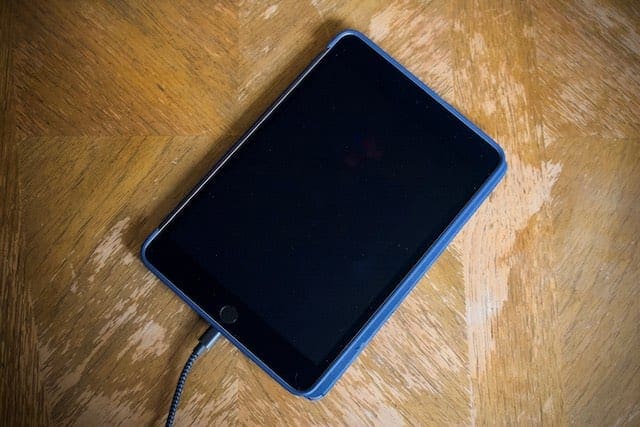 iPad plugged in to charge with a blank screen.