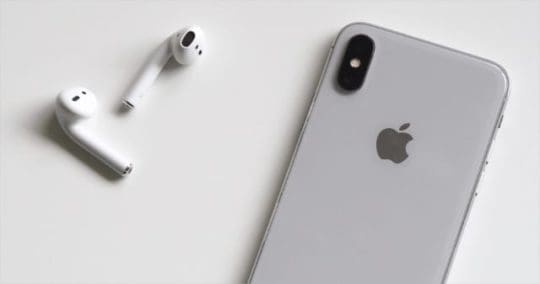 AirPods next to iphone on white surface