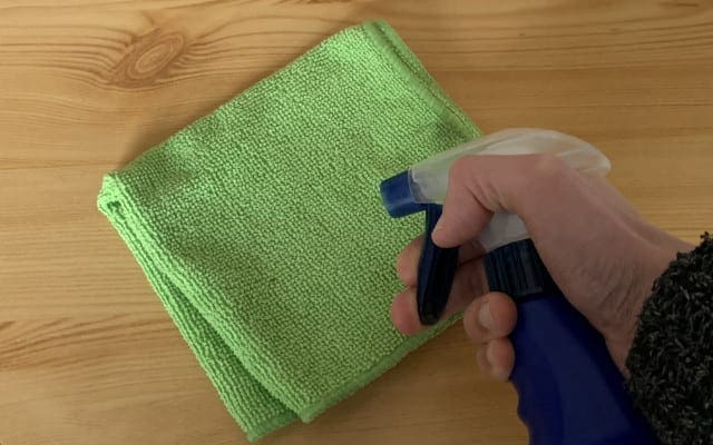 Spraying water onto a microfiber cloth