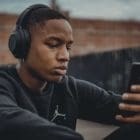 photo of a person listening to music and searching their phone