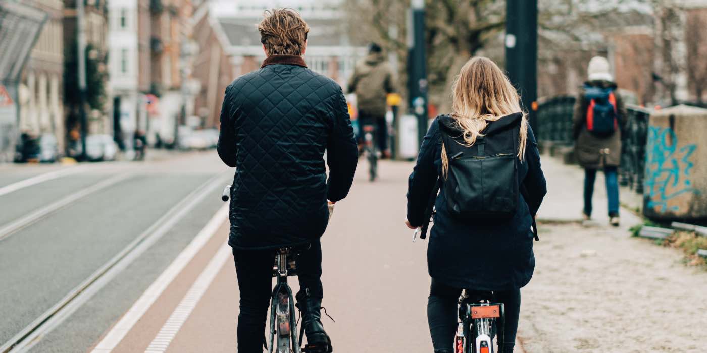 photo of two people cycling in a city next to each other