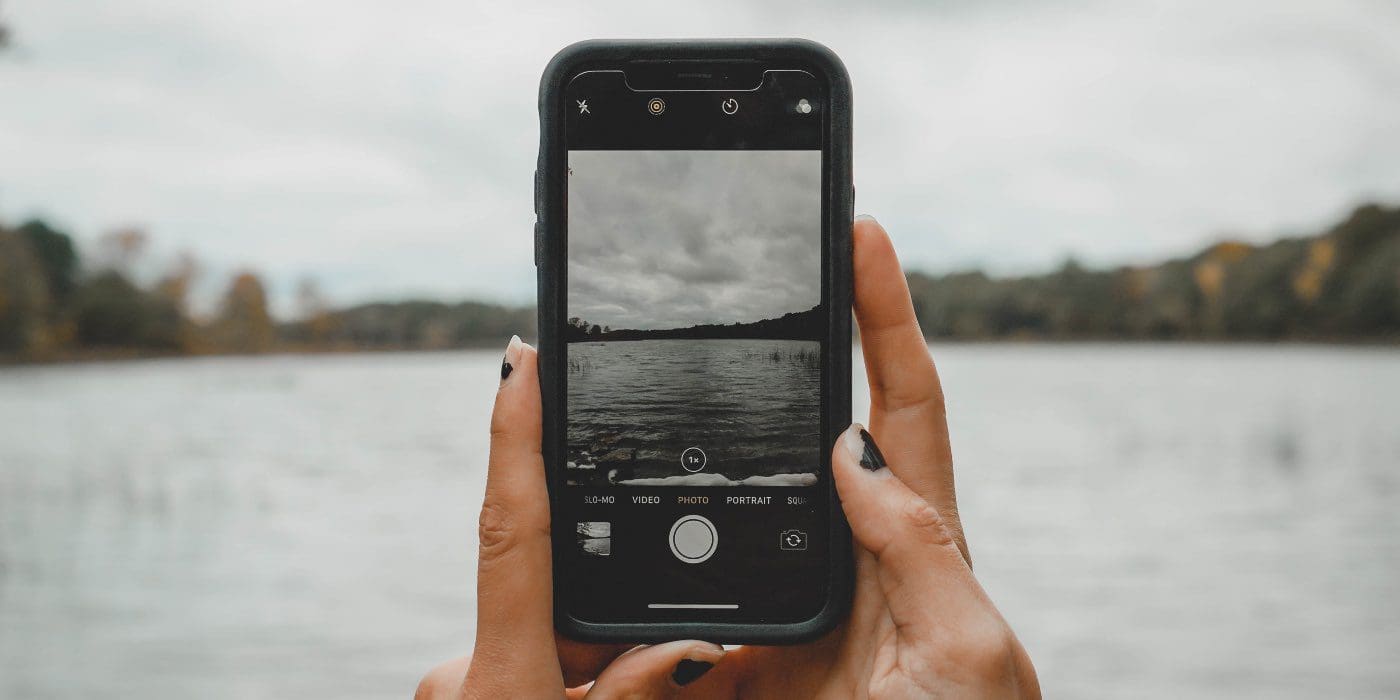 photo of a person taking a picture with the camera on their iphone