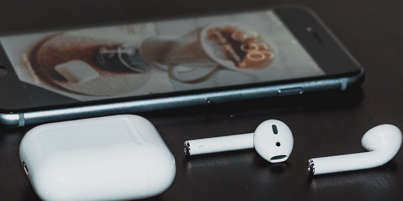 photo of airpods and an iphone on a table